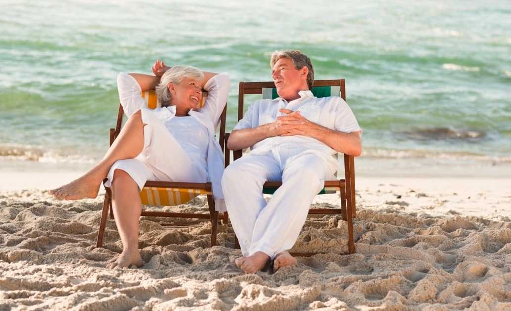 Elderly couple of tourists relaxing on the beach
